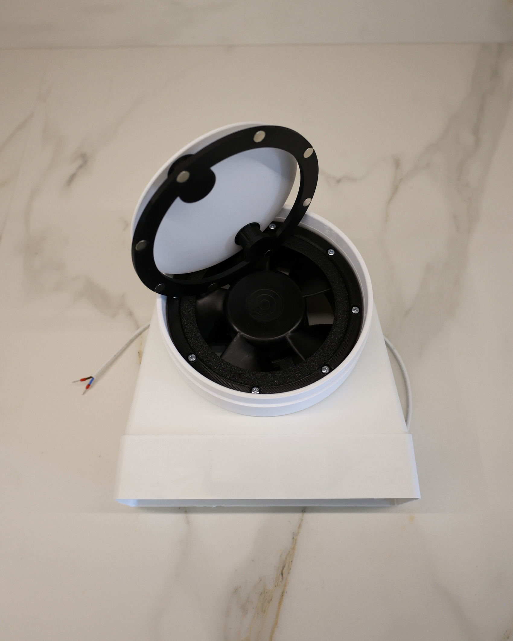 Open magnetic panel of GRATKA SLIM 150 showing fan motor and wiring access for maintenance without ceiling removal